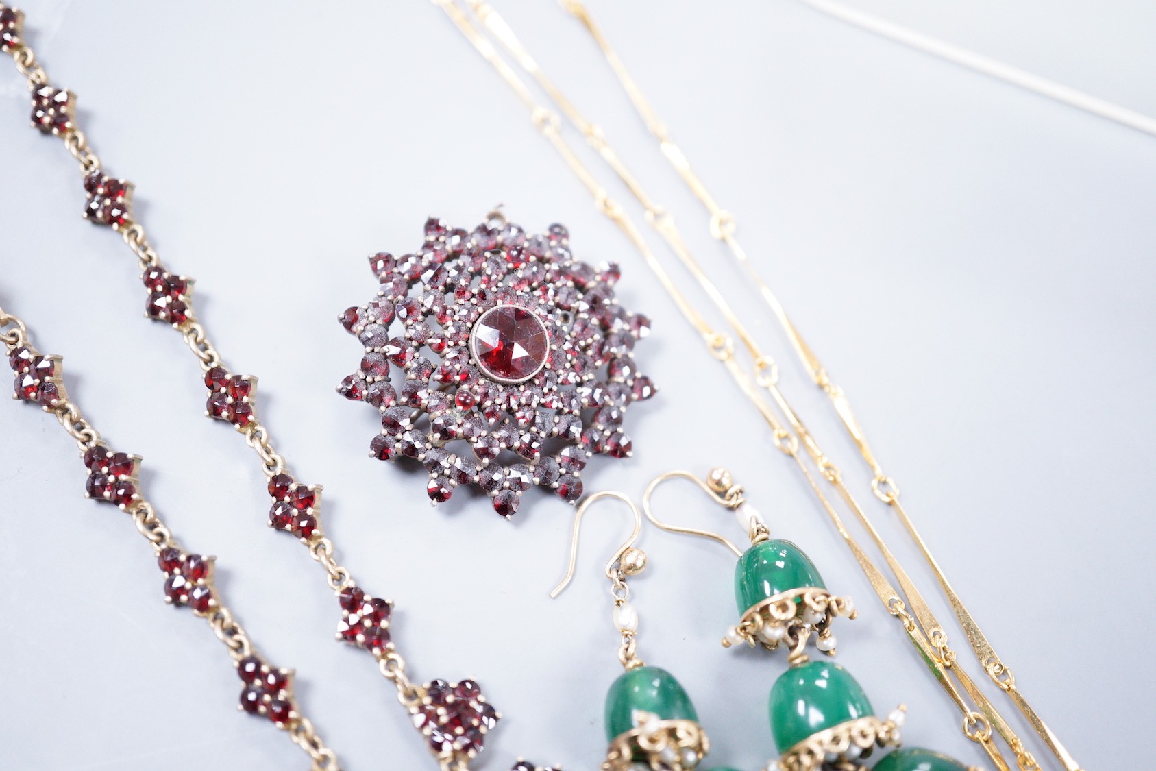 A Victorian gilt white metal and facetted garnet cluster set necklace, 42cm, a similar brooch, a pair of chrysoprase set drop earrings and a gilt metal necklace.
